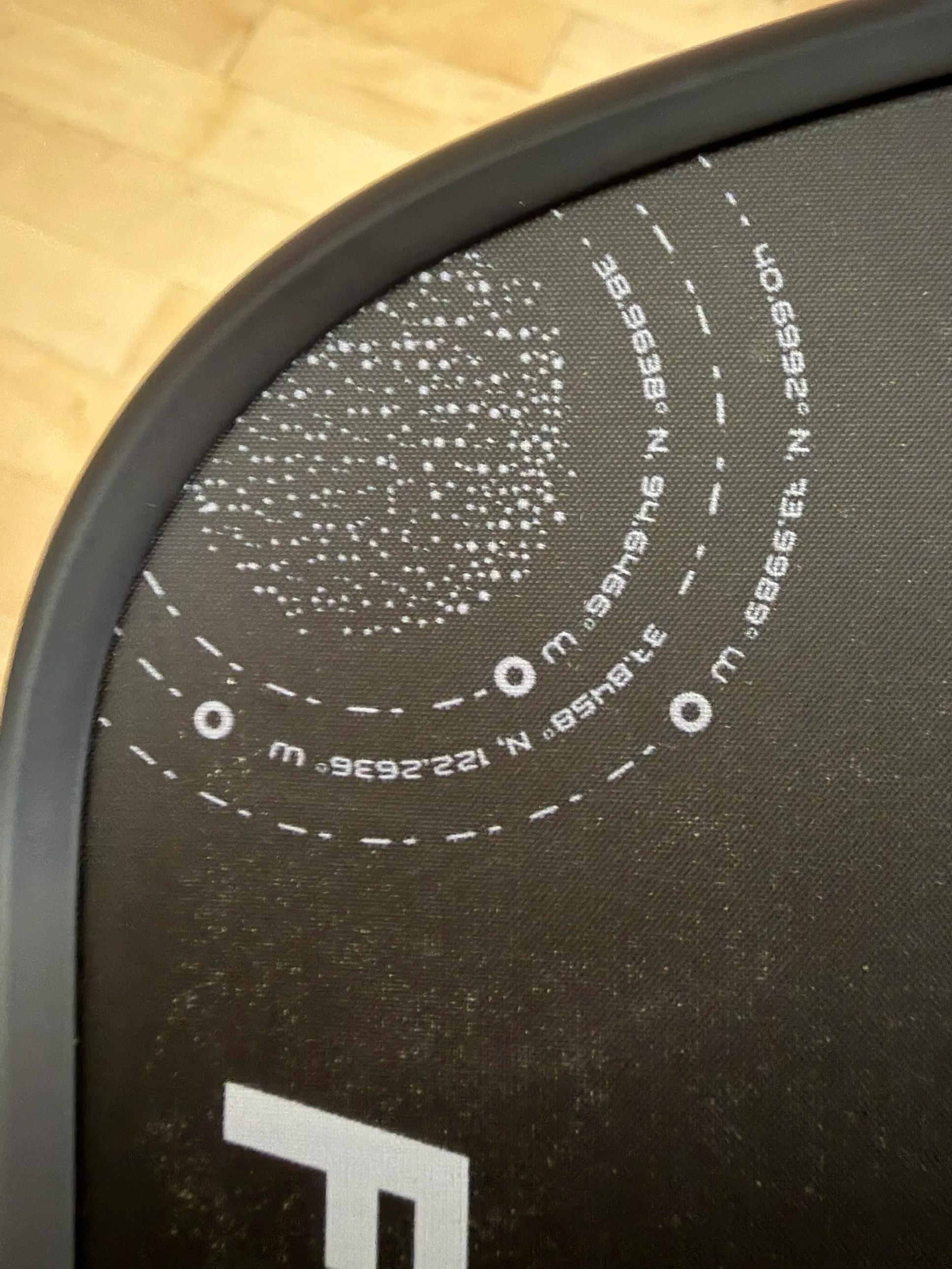 The dotted graphic and coordinates printed in the corner of the face